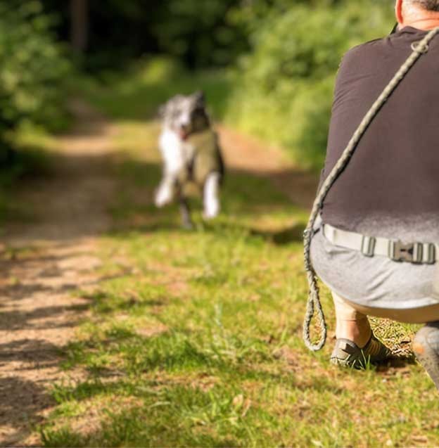 Fotografin kniet mit Kamera auf Wiese